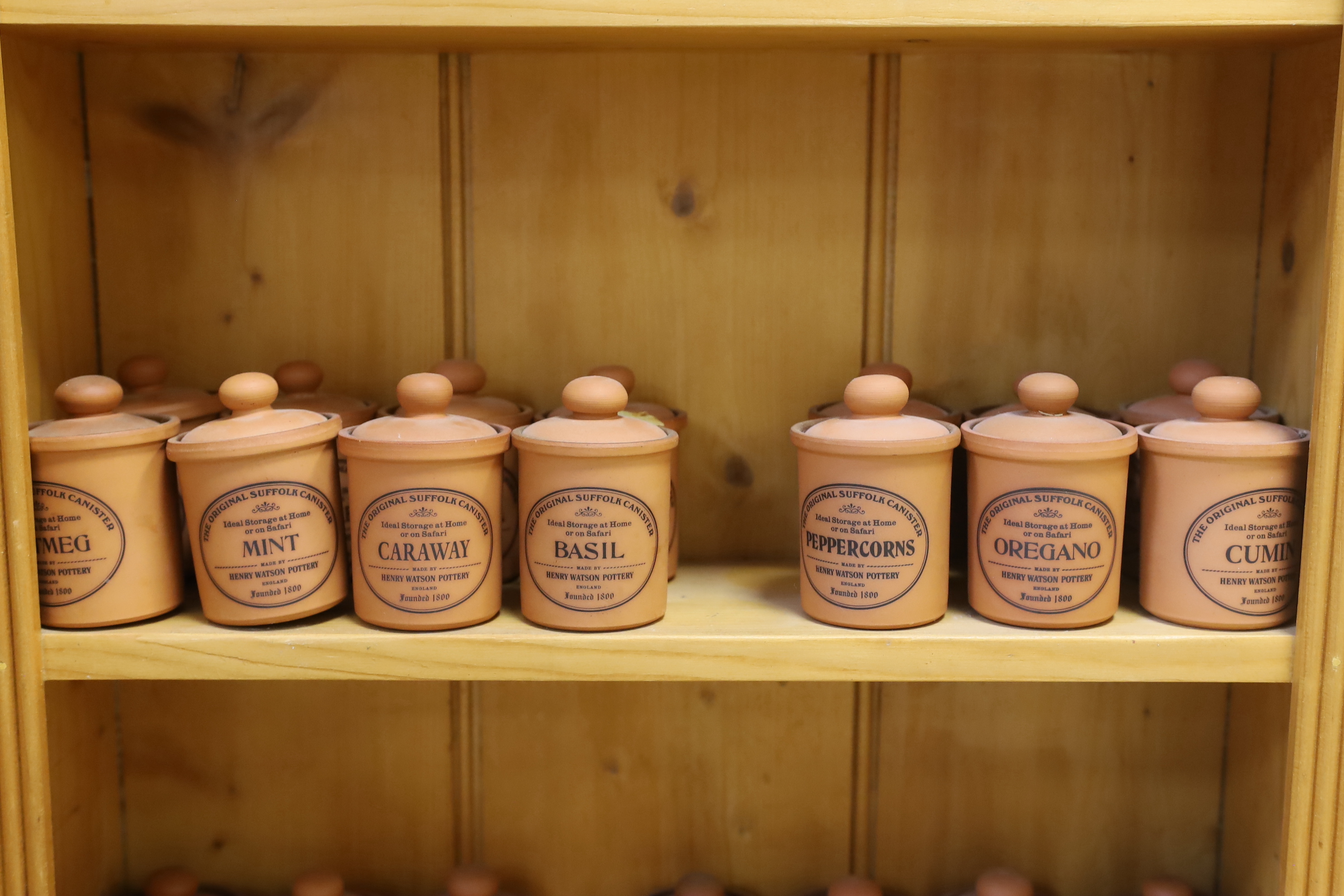 A pine kitchen spice rack with Henry Watson Pottery ‘Original Suffolk Canister’ set